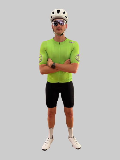 Person wearing a bright green cycling jersey and black shorts on a gray background